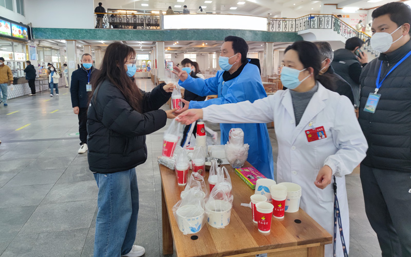 中南民族大学党员志愿者正在发放中药汤剂。