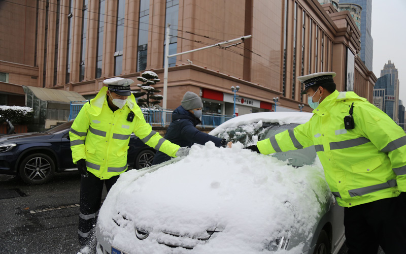 武昌交警为在途中司机清除积雪排除驾驶安全隐患。