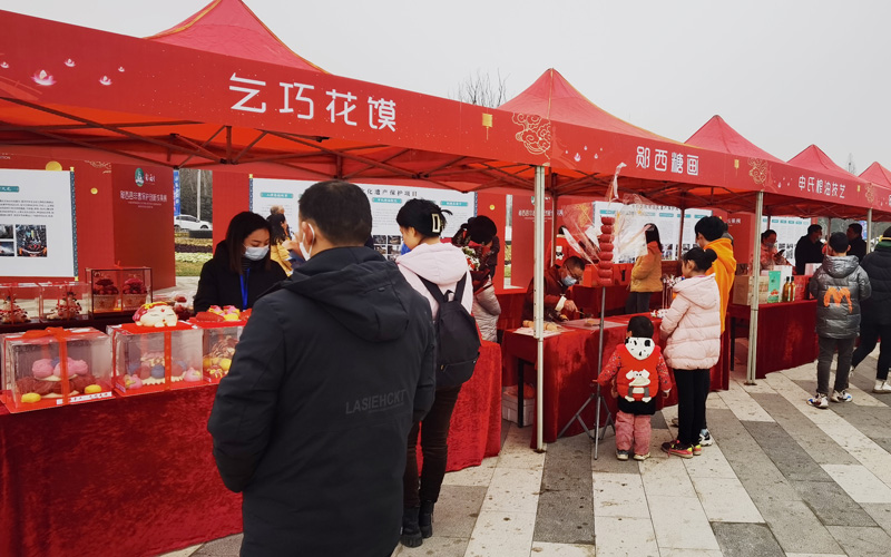 图为郧西七夕、郧西糖画、乞巧花馍、罗氏根雕技艺、申氏榨油技艺等多个非遗保护项目集中展示。  邹景根摄