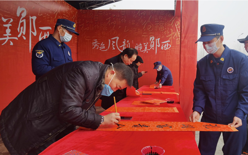 图为郧西县组织书法家协会志愿者为群众书写春联。邹景根摄