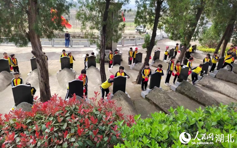 在姜能山的帶動下，當地學生清掃革命先烈墓碑。受訪者供圖
