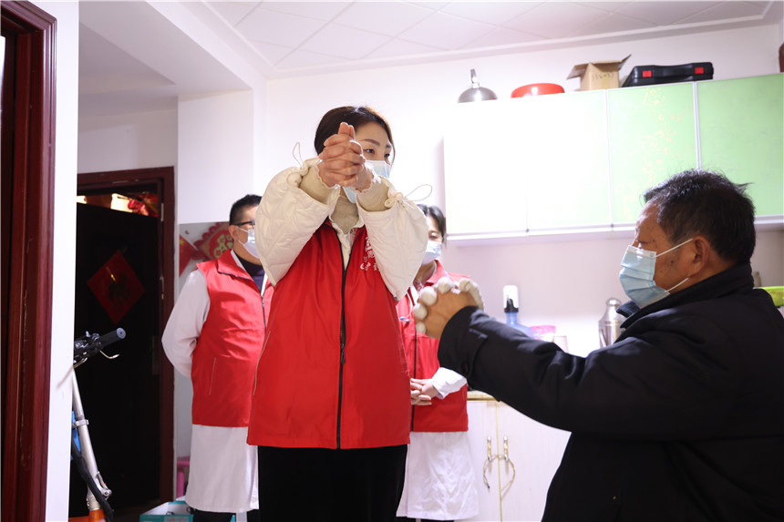 “e护到家”志愿服务队队员指导偏瘫老人进行右上肢的关节活动训练。