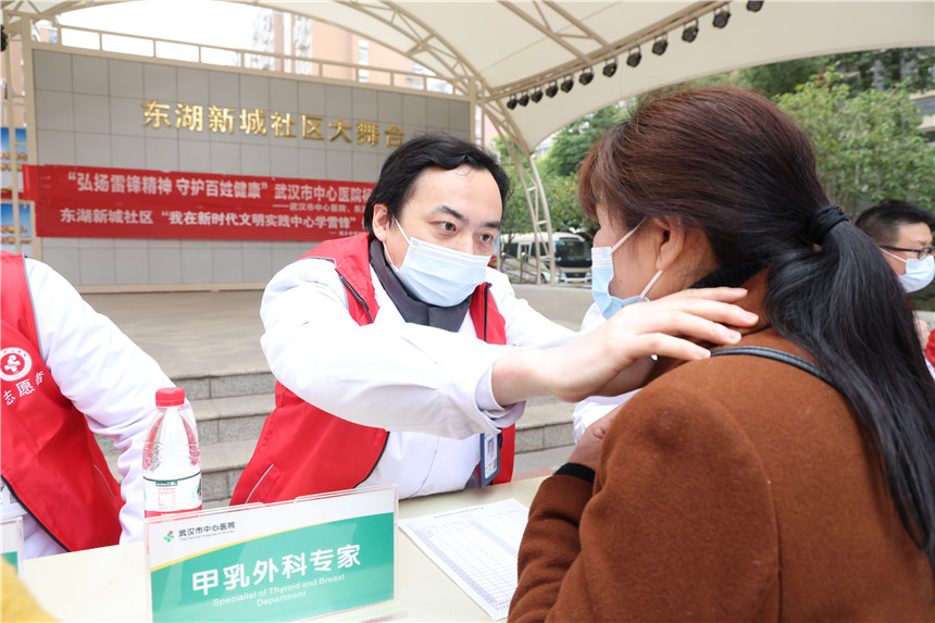 甲状腺乳腺外科专家为社区居民检查甲状腺。