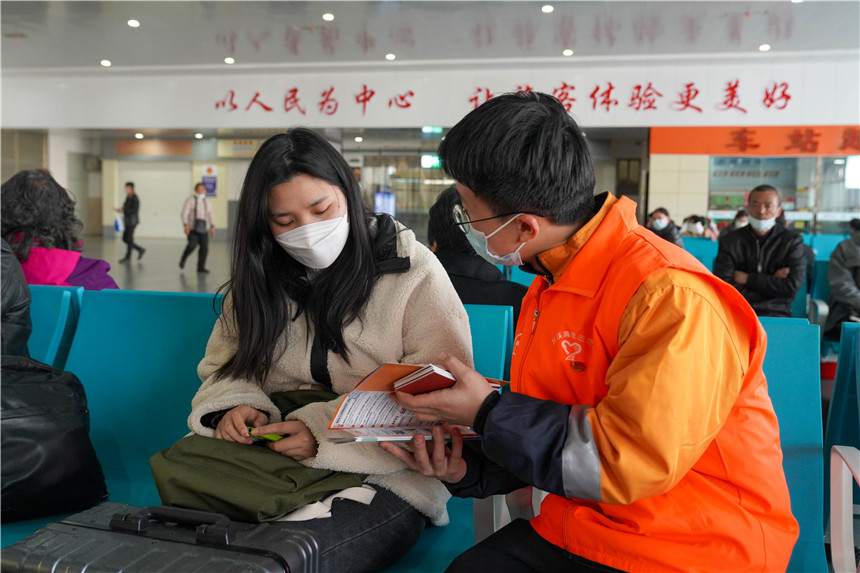志願者在候車廳為旅客講解安全乘車要點。李濤攝