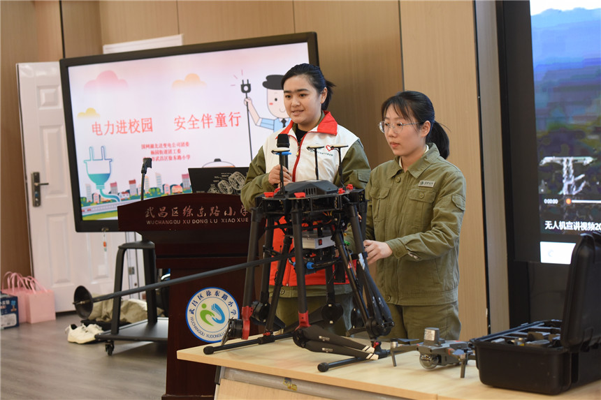 青年志愿者向学生讲授无人机在电网运维中的作业。