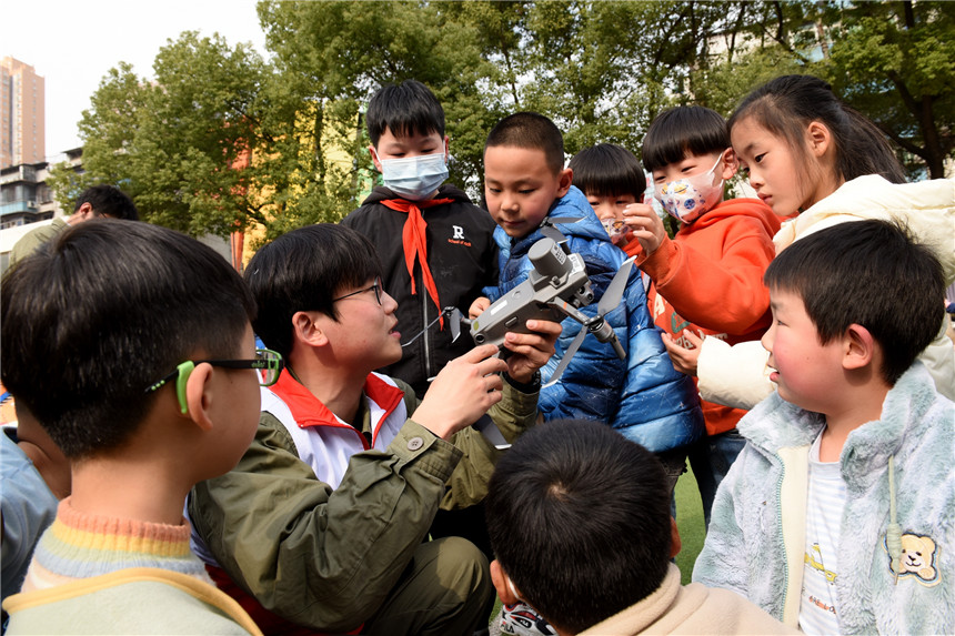青年志愿者向学生们讲授无人机构造原理。