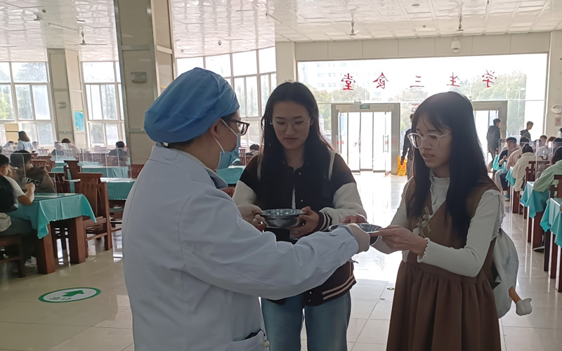 学生领取汤药，校医院志愿者细心叮嘱防治呼吸道疾病的措施。卢岚摄