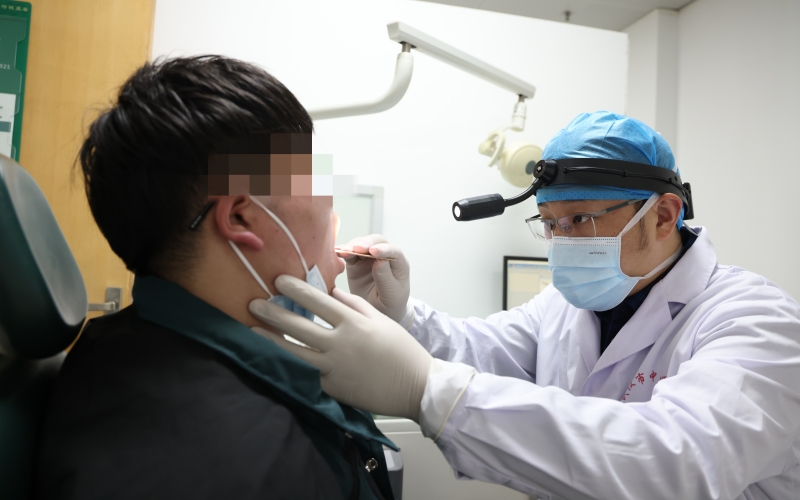 在睡眠醫學中心的睡眠呼吸障礙（鼾症）門診，耳鼻喉科主任陳偉為患者做檢查。