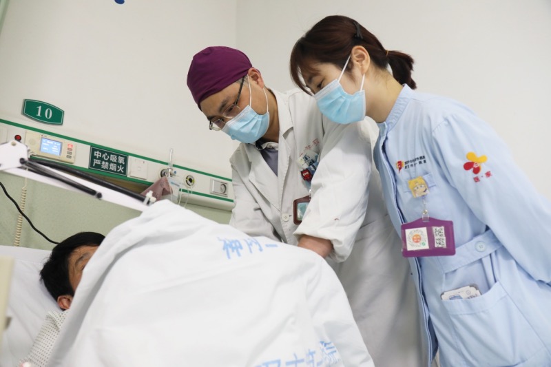 武汉一医院胃肠外科任骏医生检查张先生术后状况。代雨朦摄 