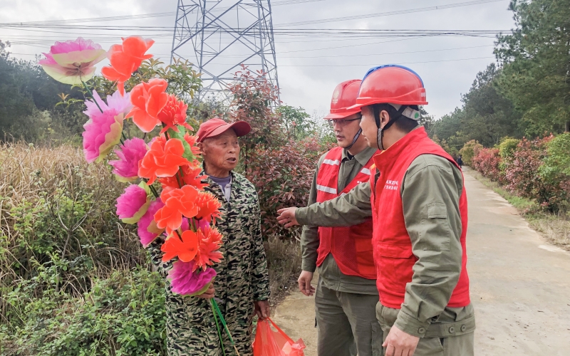 供电防山火队员正在给祭祀村民讲解防山火安全知识。