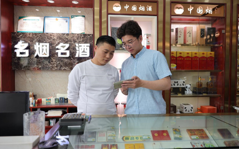 图为客户经理和零售客户一起观看宣传教育视频。