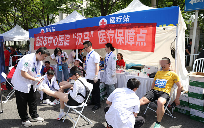 在半程马拉松终点的固定医疗点，武汉市中心医院医疗保障队医护人员有条不紊地为选手们检查身体，提供医疗救治服务。