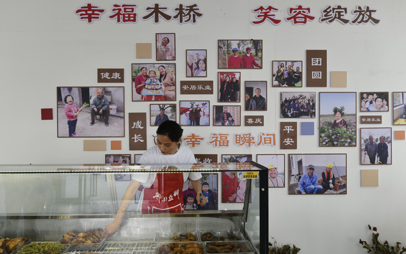 共享幸福食堂的墙上，挂满了村民幸福瞬间的照片。