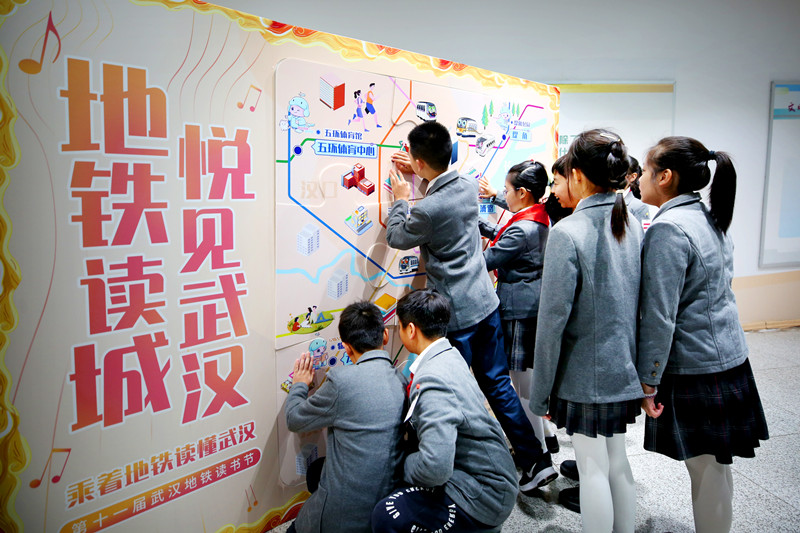 长春街小学学生代表在研究地铁出行线路。产启斗摄