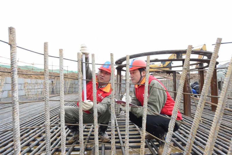 国网湖北送变电公司施工人员检查SSN2094号跨越塔基础承台钢筋铺设质量。邹小民摄