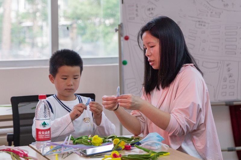 母子齐上阵制作扭扭花。黄瑞杰摄