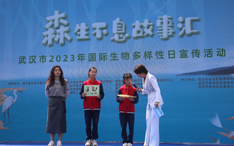 涨渡湖小学老师周晓雯，学生陈通、王心予带着他们制作的生物标本和手工制品上台，分享这些可爱标本背后的故事。