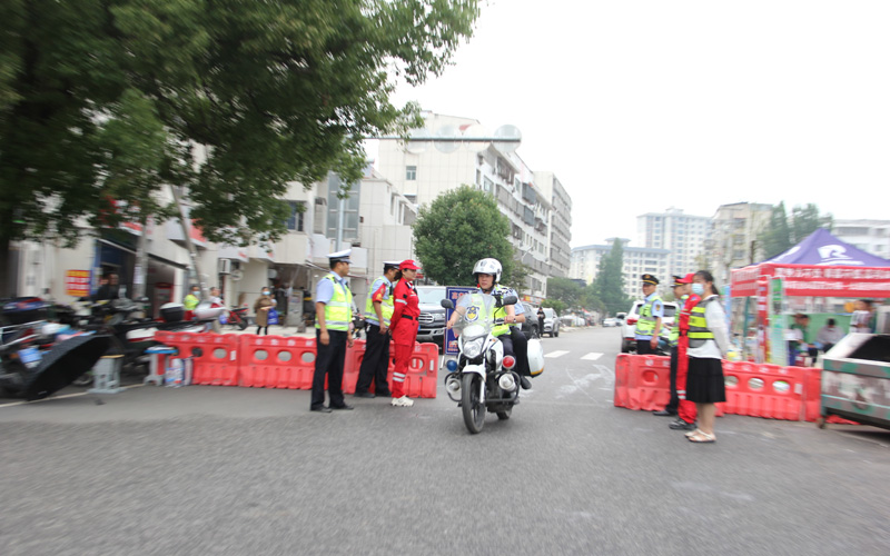枣阳市北城派出所民警彭小龙乘驾铁骑将证件交到考生