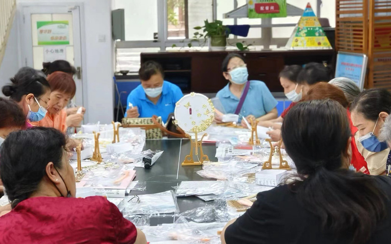 洪山路社区党员居民围坐一起制作团扇