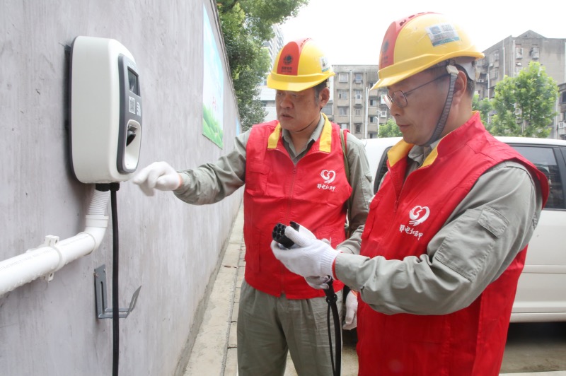 6月19日，湖北荆州供电公司员工向小区物业工作人员讲解充电操作流程。周志勇摄