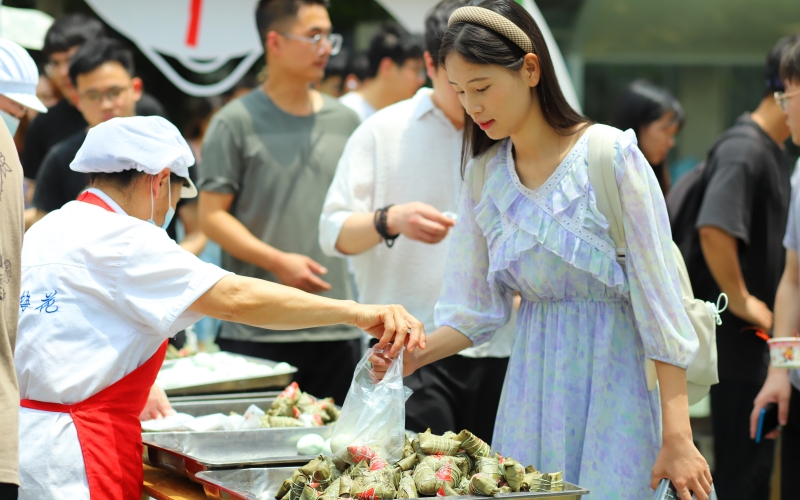 武漢輕工大學學生在領取粽子和鴨蛋。陳卓琳攝
