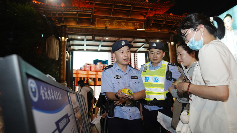 7月7日小暑時節，武昌區公安分局漢街派出所民警冒著夏日的炎炎高溫在漢街大戲台向來往游客宣傳防騙禁毒知識。孫遜攝