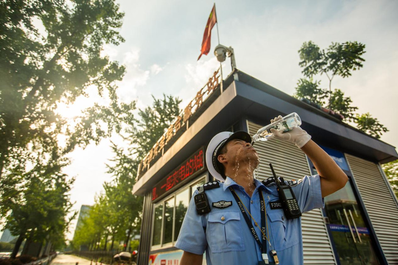 宜昌伍家交警衣衫被汗水浸透，在城東執勤崗亭補水防暑。陳華均攝