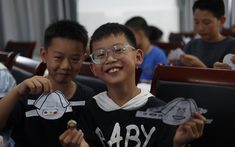 孩子们展示自己的剪纸作品 摄影；周逸文