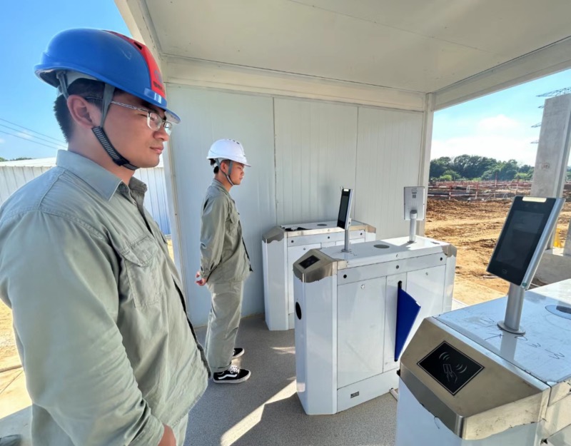 项目建设人员正通过“智慧工地”人脸识别系统进入施工现场。熊江婷摄