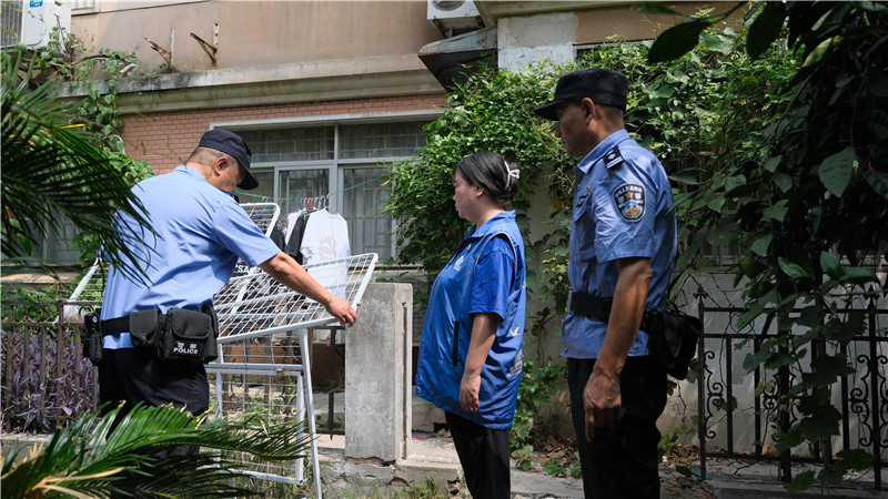 民警和网格员一道帮居民清理废弃物。