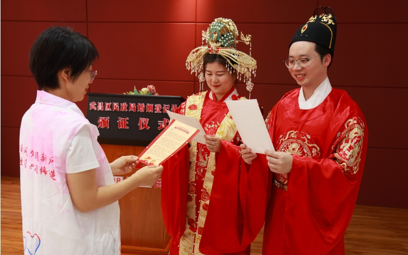婚俗新风志愿者向新人发放《婚事简办新办廉办倡议书》。