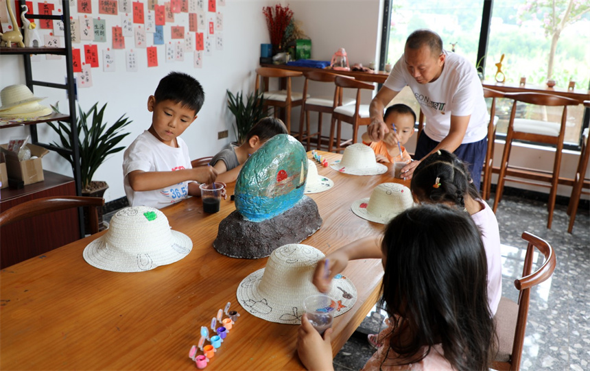竹山县擂鼓镇西河村“童伴之家”暑期辅导留守儿童学习绘画。