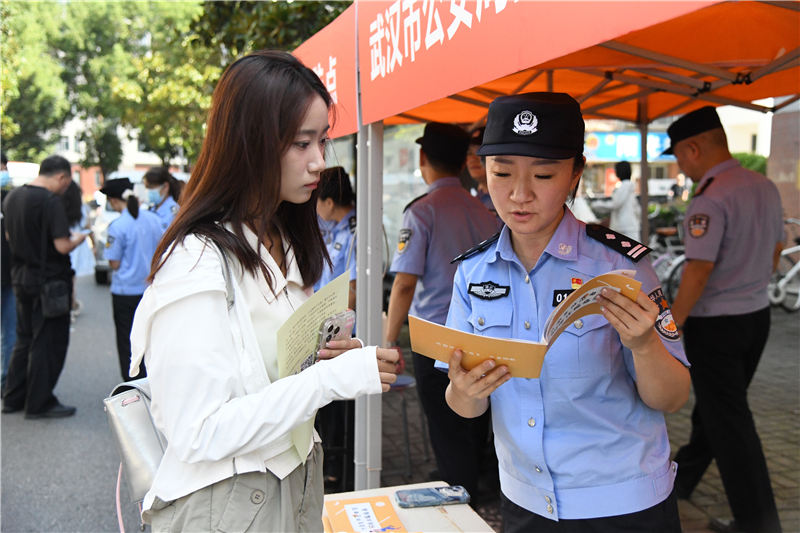 民警为华中农业大学新生介绍防电诈指南。