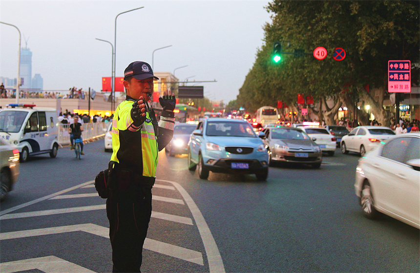 执勤交警指挥车辆有序通行。