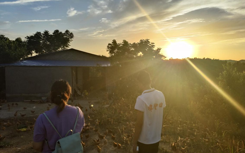 记者与“谭种田”在夕阳下的合影