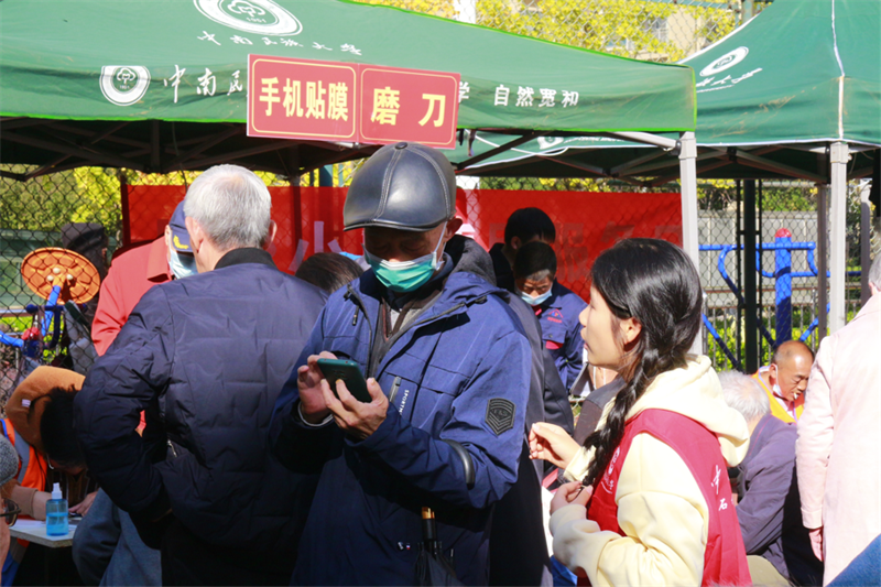 手机贴膜摊位、磨刀摊位人头攒动。罗怡摄