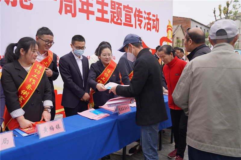 黄梅县纪委监委干部设点摆摊，向群众宣传纪检监察信访举报知识。