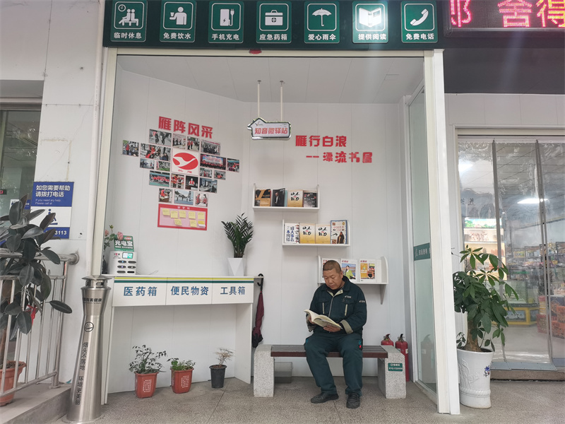 一名户外工作在驿站前看书。