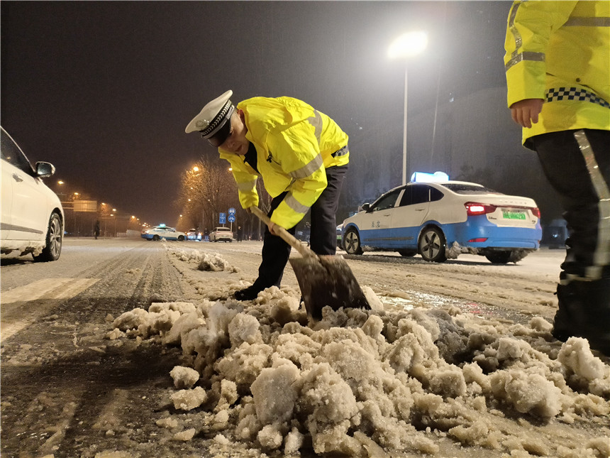 民警进行道路铲雪工作。焦轩摄
