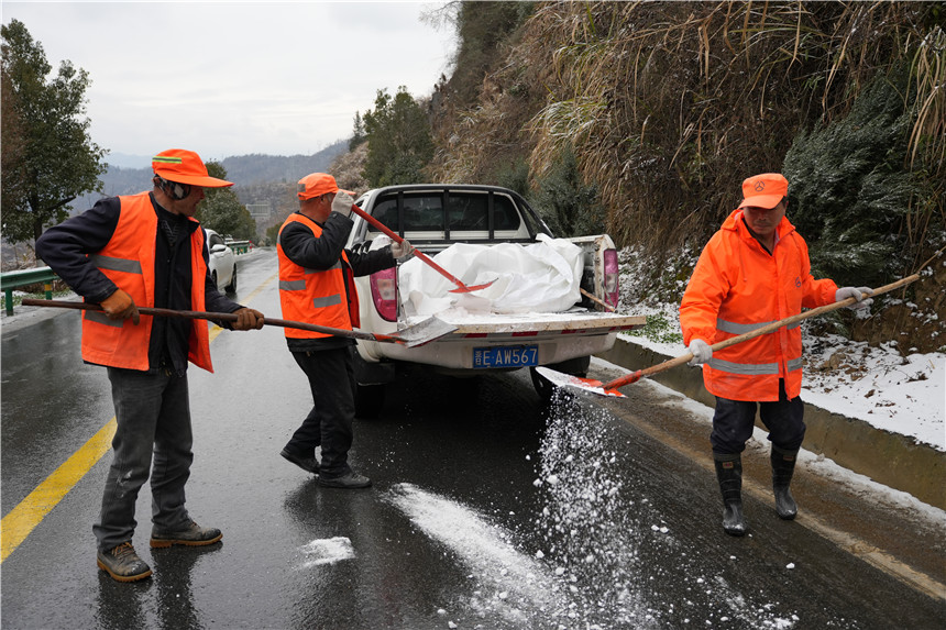 竹山縣公路養護中心工作人員在242國道上庸路段拋撒融雪劑。岳文靜 夏甜攝影報道