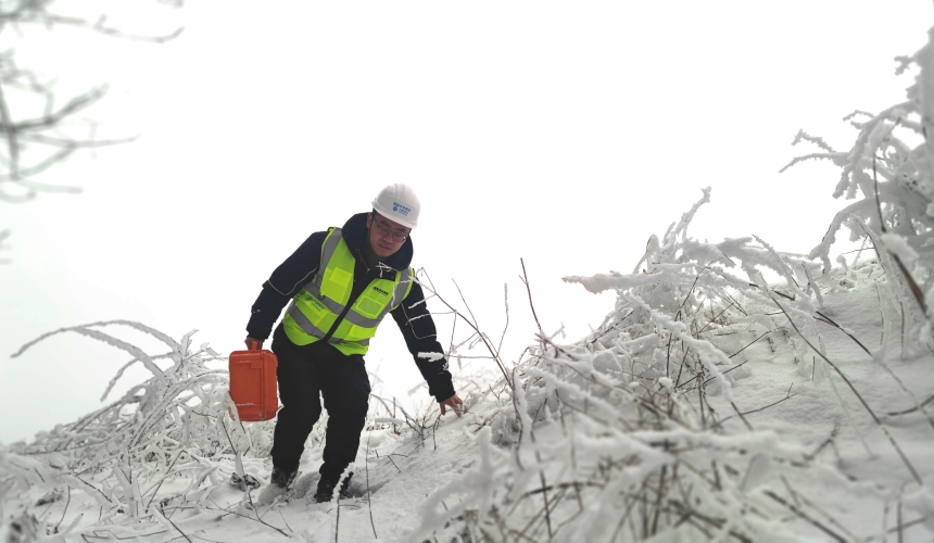 網絡保障人員艱難行走在雪地中進行通信設施巡檢。
