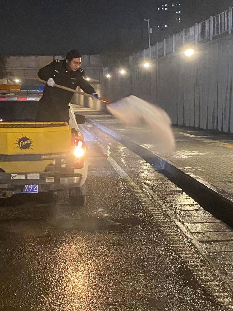 執法隊員人工撒融雪劑。