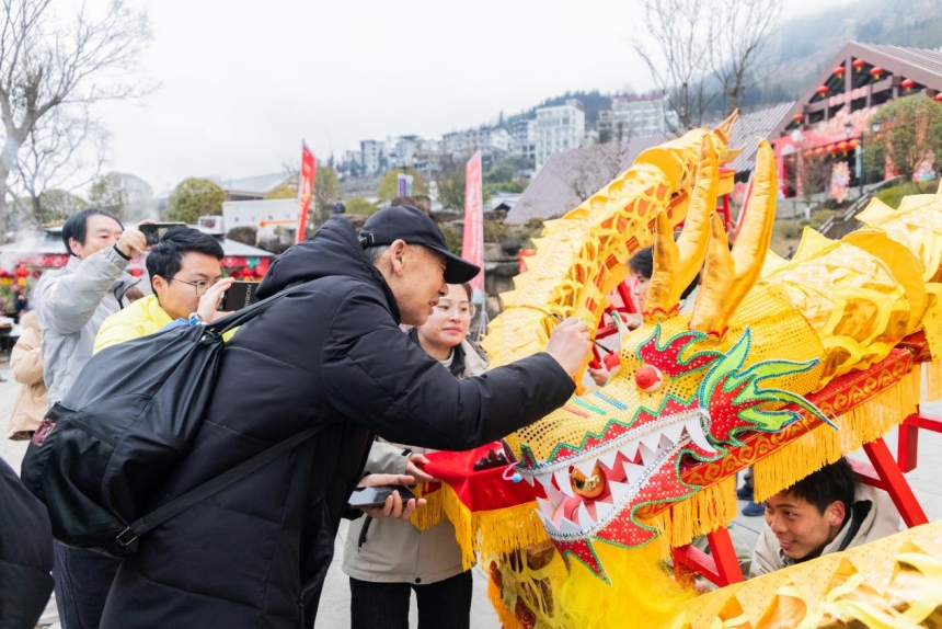 幸運游客拿起毛筆為龍“點睛”。