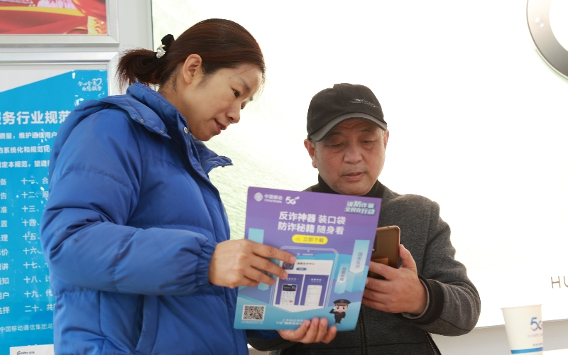 湖北移动工作人员介绍讲解并指导用户安装“国家反诈中心”APP”。