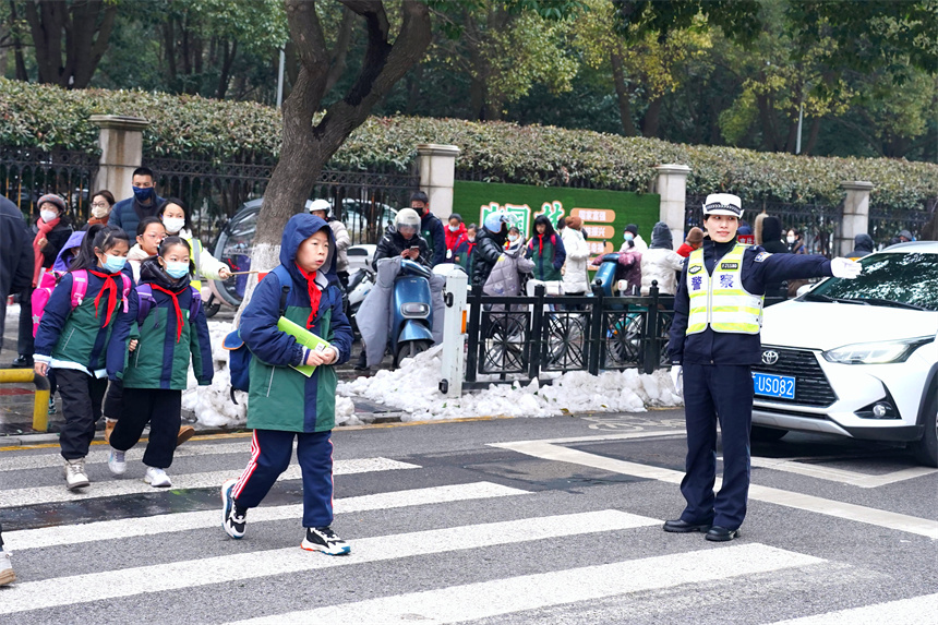 襄阳市公安局襄城区分局鼓楼警务平台“女警护学队”在荆州街小学“护学岗”上指挥疏导交通。