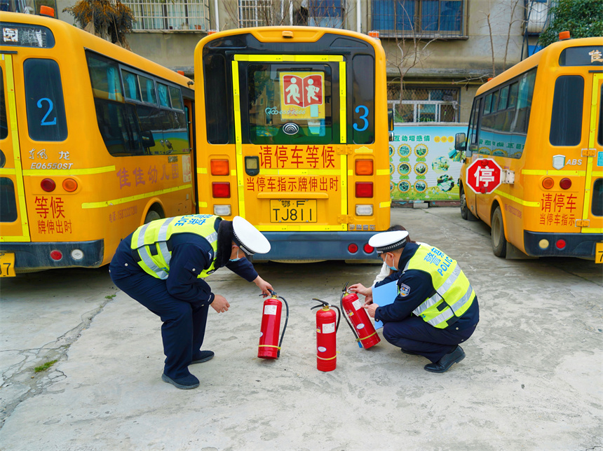 襄阳市宜城市公安局交警大队民警开展校车“体检”，检查车内消防设备。