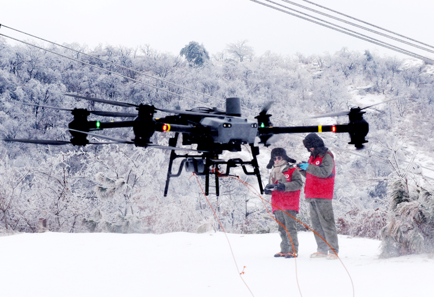 500千伏孝浉一二回線女飛手用重載無人機挂載自垂式震動除冰裝置。鄒小民攝