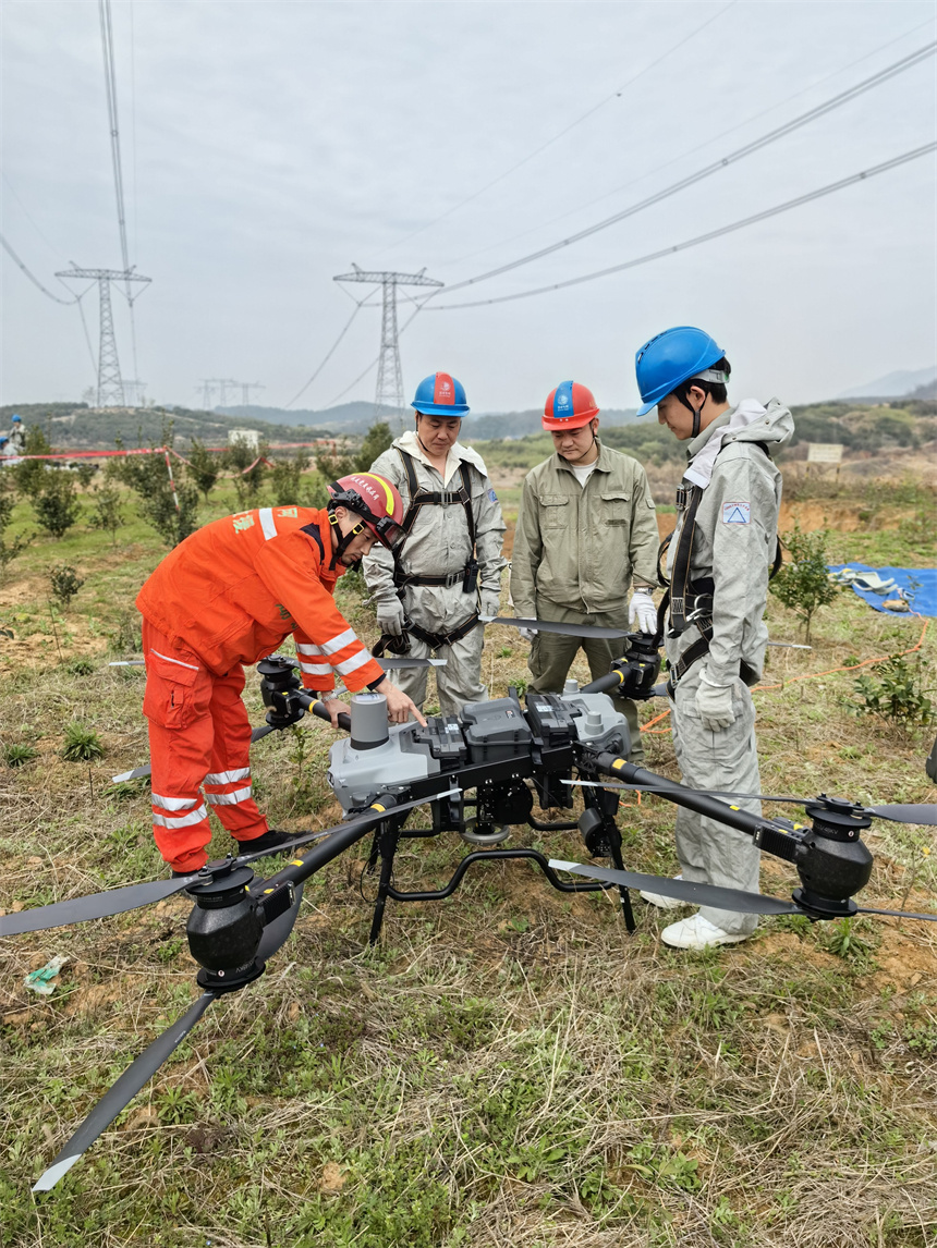 湖北送变电公司员工章自胜为新员工讲解重载无人机操作要领。王明摄