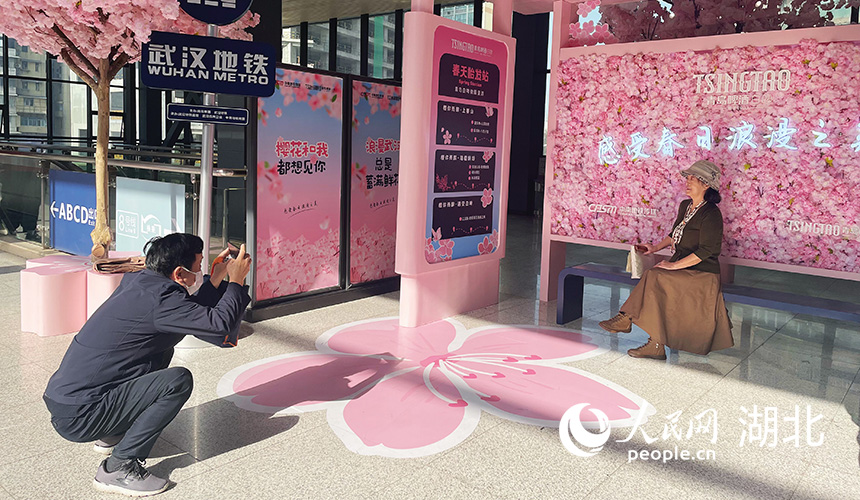 在武汉地铁1号线黄浦路站，市民纷纷在樱花站台拍照打卡。人民网记者 周恬摄