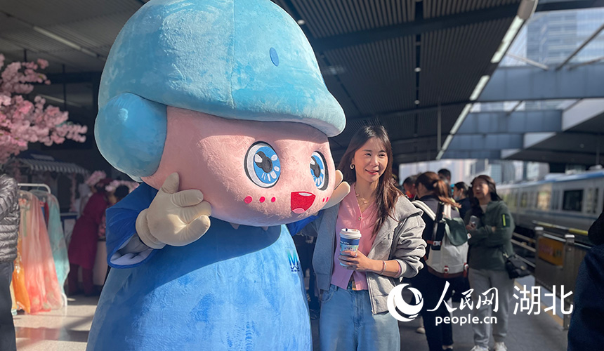 在武漢地鐵1號線黃浦路站，市民與武漢地鐵IP形象江豚“魚快快”拍照合影。人民網記者 周恬攝